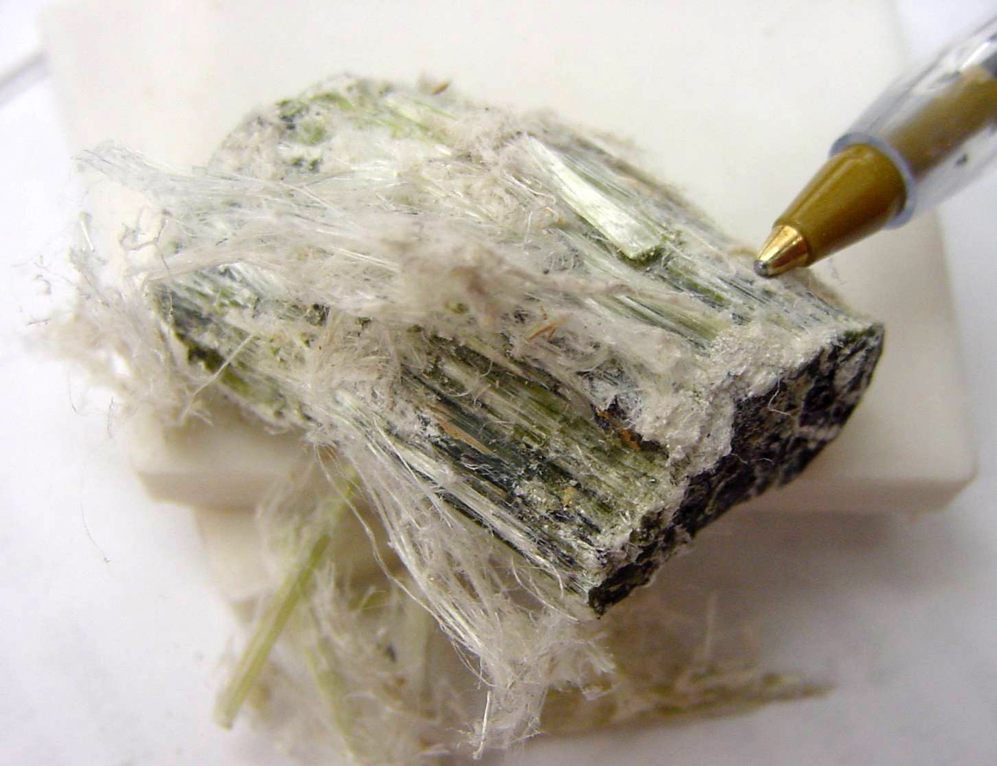 Chrysotil — Weißasbest mit feinen Mineralfasern, Größenvergleich mit Kugelschreiber